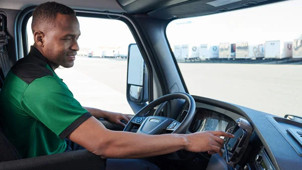 ODFL driver using an electronic logging device (ELD) inside the cab of a freight truck.