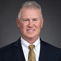 Headshot of Steve Hartsell, Senior VP of Sales, wearing a dark suit and gold tie.