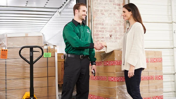 ODFL employee shaking hands with customer in front of expedited LTL freight delivery.
